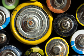 Obraz premium Close up of positive ends of discharged batteries of different sizes and formats, selective focus. Used alkaline battery with corrosion and rust. Hazardous garbage concept