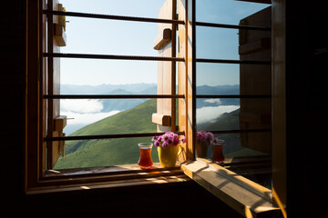 A glass of tea in front of the window in the hand from Rize mountains.