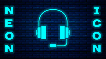 Glowing neon Headphones icon isolated on brick wall background. Support customer service, hotline, call center, faq, maintenance. Vector Illustration.