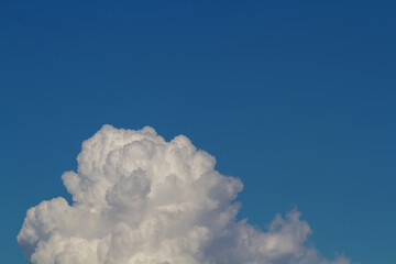 White cumulus clouds close up. Blue sky. Delicate background.