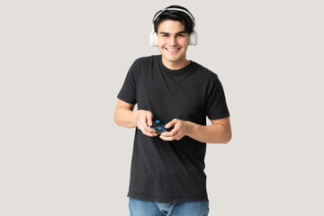 Naklejka premium Smiling Latin Man Playing Video Game In Studio