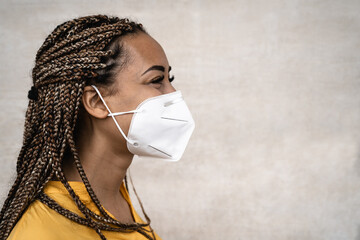 African woman with braids wearing face medical mask - Young girl using facemask for preventing and...