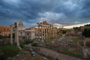 View of the Roman Forum with thunderstorm clouds. From the Campidoglio they can be seen the Arch of Severus, the temples Saturn and Vesta, temple of Vespasiano, Arch of Titus, Colosseum Rome, Italy.