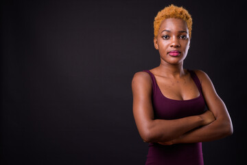 Young beautiful African woman against black background