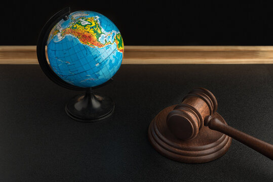 Wooden Judge gavel and globe. International Environment law. Law and justice court concept.