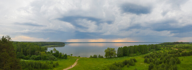 thunderstorm over forest and lake in autumn.