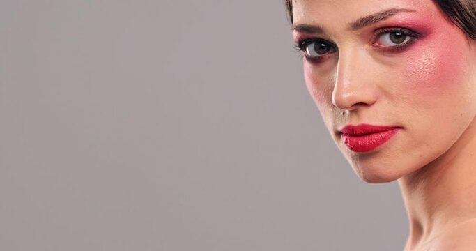 Slow motion footage  of a woman turns to the camera, close-up eyes with a orange makeup.  White model with bright eye makeup looking to the camera. Beautiful girl with a fashion vivid red make-up.