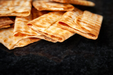 Hot crispy biscuits stacked on black marble. Freshly baked cookies. Selective soft focus.