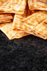Fresh crispy biscuits stacked on black marble. Freshly baked cookies. Selective soft focus.