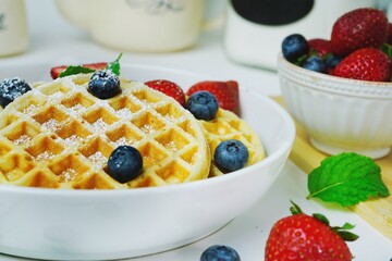 Homemade Mini Waffles topped with fresh berries, selective focus