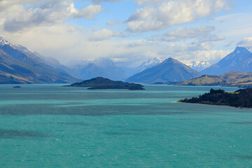 The view of Lake Wakatipu with clouds covering the snow-capped mountains in the distance. From the view of Bennetts Bluff Lookout.