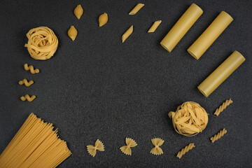 Different types of pasta on grey background. Dry pasta. Italian kitchen. Copy space