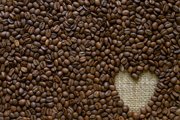 Heart shaped on a background of coffee beans.Texture abstract background.  Horizontal background.  concept for design or For add text . Background. Close Up.