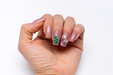 Beige New Year's manicure with Christmas tree convex toys and a New Year tree. Festive nail design.