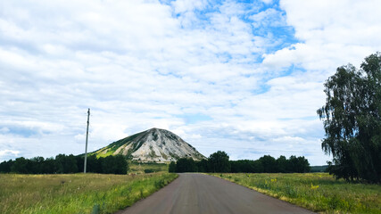 Ufa, Russia June 20, 2020 view of a rocky mountain in the middle of a green field on a sunny day