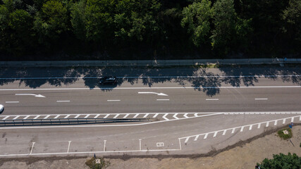 Aerial view from above of curve highway road with a car with green forest in Russia