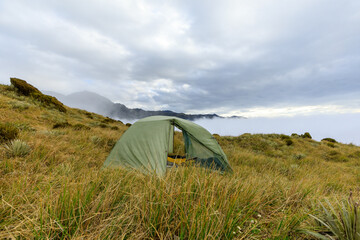 A tent for wild camping at the summit of Alex Knob with a cloud inversion in the background. Franz...