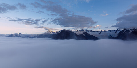 Fototapeta na wymiar Cloud inversion over the Franz Josef valley with most of Franz Josef Glacier obscured by the clouds. After sunset, at dusk, from the view of the summit of Alex Knob. Franz Josef Glacier, New Zealand