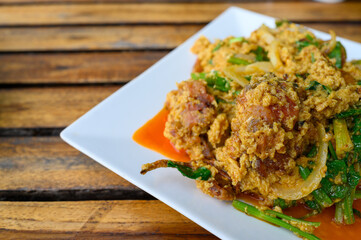 Stir Fried Soft Shell Crab in Curry Powder on wooden table, Thai food