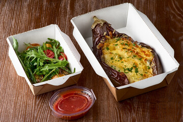 Baked eggplant, meat stews on a carton box take away