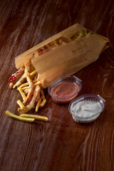Takeaway food. french fries and vegetables in batter, carrots, sweet peppers, cured and sauces on a wooden board
