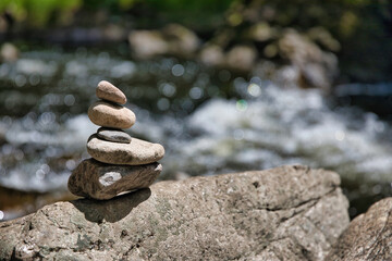 Yoga, Meditation - aufeinandergestapelterunde Steine am Fluss