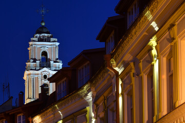 Fototapeta na wymiar Cathedral tower over old houses at night in Vilnius, Lithuania