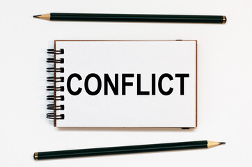 WHITE SPIRAL NOTEBOOK, TWO PENCILS WITH TEXT CONFLICT