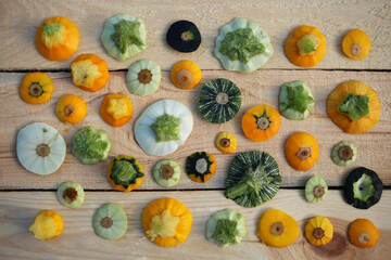 Colored trimming tails of zucchini off different sizes on a wooden table.