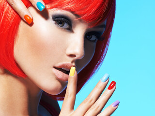 Portrait  of a model with red hairs and multicolor nails.