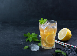 Lemon ice tea on dark background with mint and ice