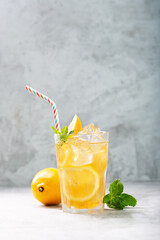 Lemon ice tea on concrete gray background with mint and ice