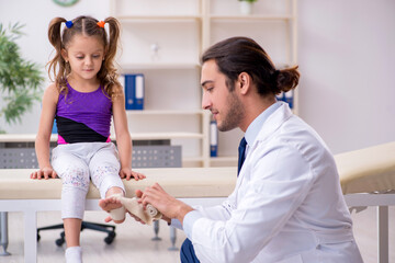 Small girl visiting young male doctor