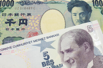 A macro image of a Japanese thousand yen note paired up with a red, ten lira bank note from Turkey.  Shot close up in macro.