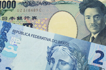 A macro image of a Japanese thousand yen note paired up with a blue two real bank note from Brazil.  Shot close up in macro.