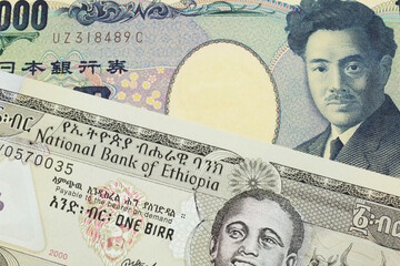 A macro image of a Japanese thousand yen note paired up with a grey Ethiopian one birr bill.  Shot close up in macro.