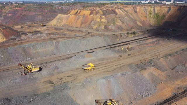 Heavy dump truck carrying the iron ore on the opencast mining aerial view.
