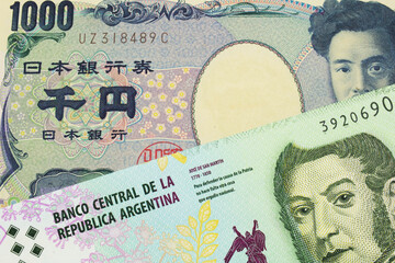A macro image of a Japanese thousand yen note paired up with a colorful five peso note from Argentina.  Shot close up in macro.