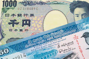 A macro image of a Japanese thousand yen note paired up with a blue and white fifty rupee bank note from Sri Lanka.  Shot close up in macro.