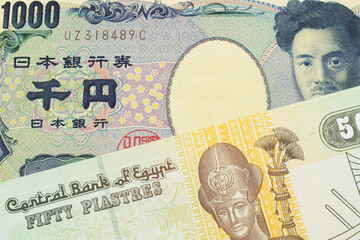 A macro image of a Japanese thousand yen note paired up with a green and yellow fifty piastre note from Egypt.  Shot close up in macro.