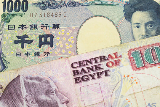A macro image of a Japanese thousand yen note paired up with a pink and purple ten pound bank note from Egypt.  Shot close up in macro.