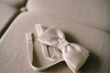 Untied white bow tie on a soft white background.