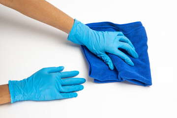 Close up of hands in rubber protective blue gloves cleaning the blue surface with a rag. Home, housekeeping concept