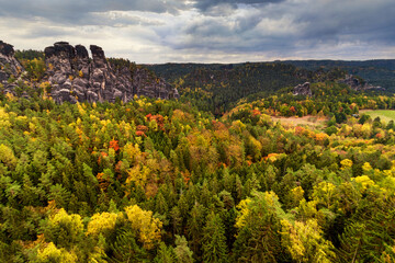 Fototapeta na wymiar Amazing autumn landscape in Saxon Switzerland National Park. View of exposed sandstone rocks and forest hilly at sunset.Germany. Europe. Concept of outdoor recreation in natural settings out of town.