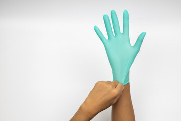 Female hand wears a protective glove for cleaning or tidying. Woman's hand latex glove gesture isolated on white. Female hand putting on latex glove isolated on white background