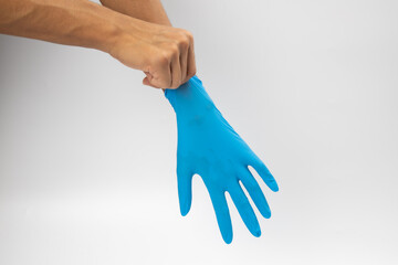 Female hand wears a protective glove for cleaning or tidying. Woman's hand latex glove gesture isolated on white. Female hand putting on latex glove isolated on white background