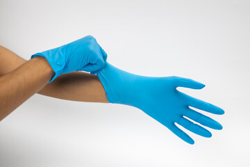 Female hand wears a protective glove for cleaning or tidying. Woman's hand latex glove gesture isolated on white. Female hand putting on latex glove isolated on white background