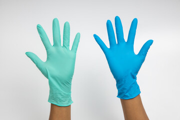 Obraz premium Woman hand wearing a Green and blue rubber medical glove on white isolated background.
