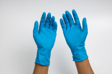 Obraz premium Woman hand wearing a blue rubber medical glove on white isolated background.