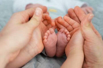Obraz na płótnie Canvas Selective focus shot of newborn baby's feet with hands around it